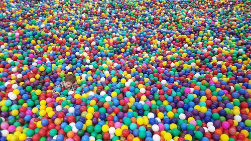 High angle view of boy in colorful ball pool