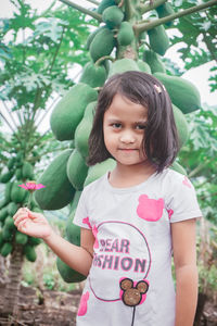 Portrait of cute girl standing against plants