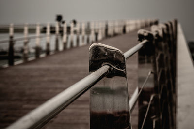 Close-up of wooden post on pier against sky