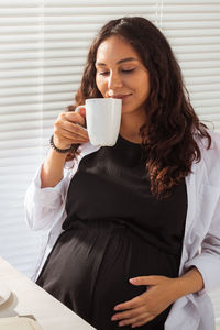 Young woman drinking coffee cup