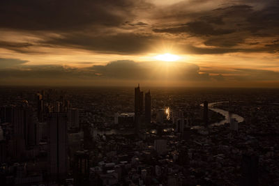 Aerial view of buildings in city during sunset
