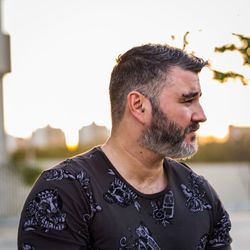 Bearded mid adult man looking away against sky