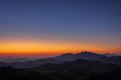 Scenic view of silhouette mountains against sky during sunset