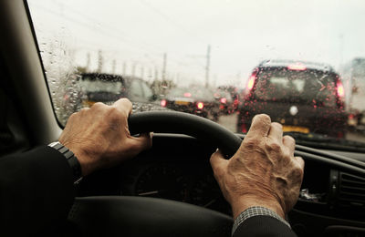 Cropped hands of man driving car