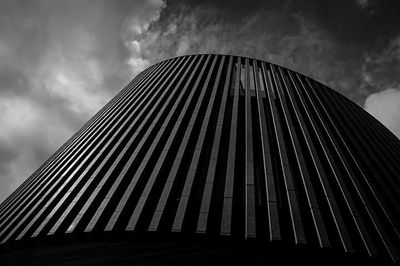 Low angle view of modern building against cloudy sky