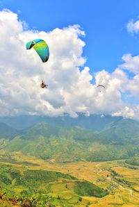 Low angle view of person paragliding against sky