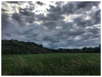 Scenic view of field against cloudy sky