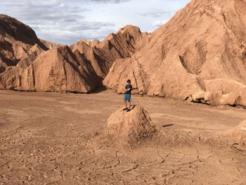 Rear view of man walking on rocks