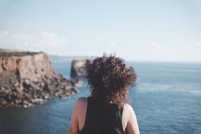 Rear view of woman looking at sea against sky
