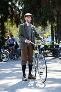 Full length portrait of man with bicycle in city