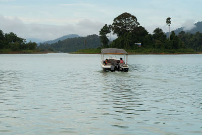 Boat sailing on river against sky