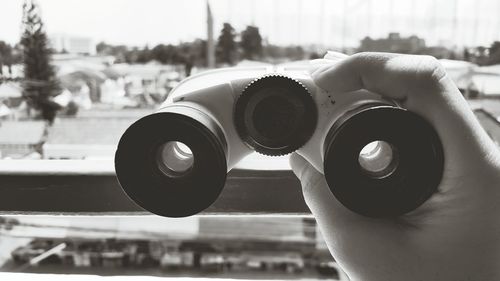 Cropped image of hand holding binoculars