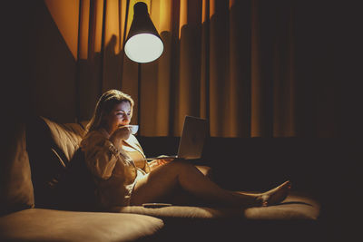 Young woman using mobile phone at home