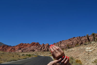 Woman's hands against country road