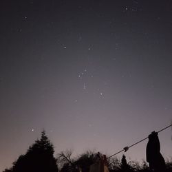 Low angle view of silhouette trees against sky at night