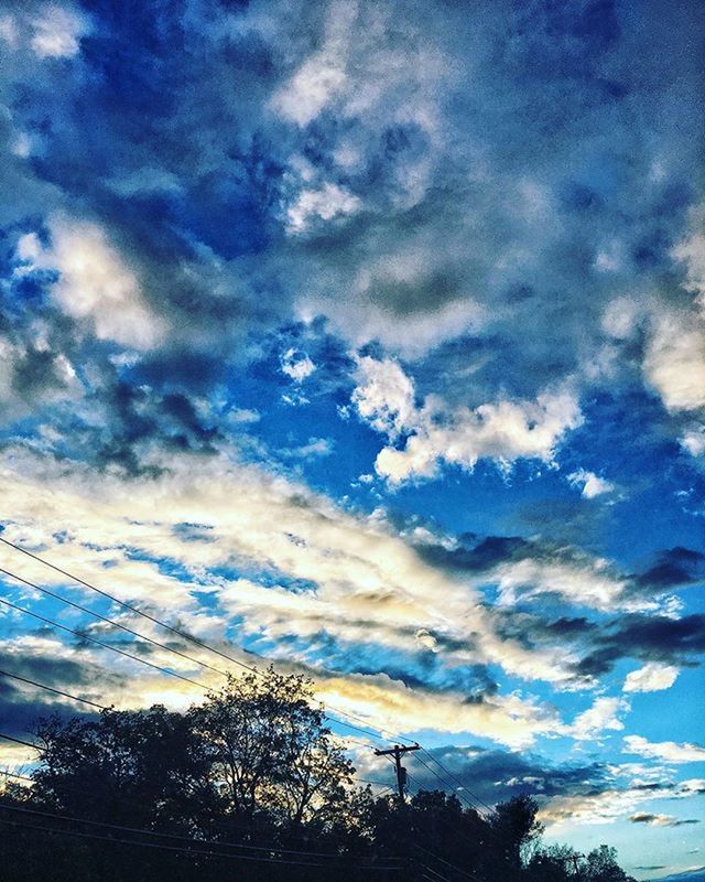 sky, low angle view, tree, cloud - sky, tranquility, silhouette, beauty in nature, scenics, tranquil scene, blue, cloudy, nature, cloud, sunset, power line, outdoors, no people, idyllic, cloudscape, dusk