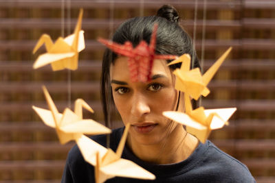 Portrait of woman looking at origami decoration