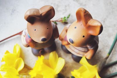 Close-up of figurines with yellow flowers on table