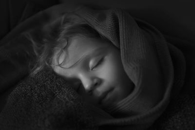 Close-up of baby sleeping on bed at home