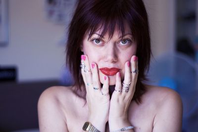 Close-up portrait of woman with red lipstick at home