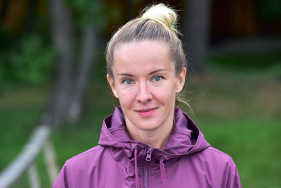 Portrait of smiling woman standing at park