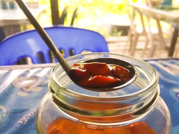 Close-up of fish suace with chilli in glass jar on table