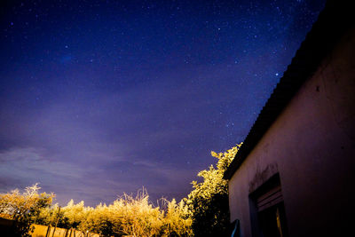 Low angle view of house against star field at night