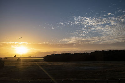 Scenic view of sunset over silhouette landscape