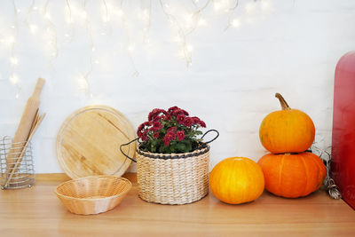 Various fruits in basket on table against wall