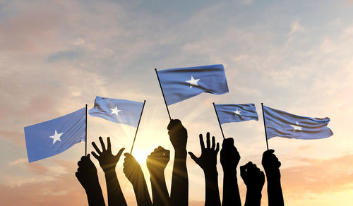 Low angle view of silhouette flags against sky during sunset