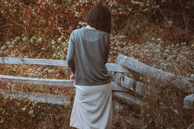 Rear view of woman standing on field