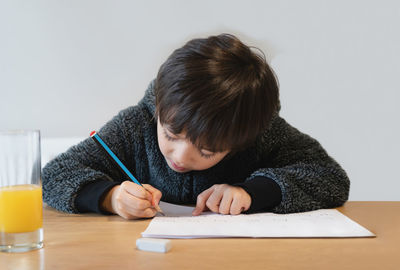 Rear view of boy looking at camera at home