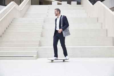 Businesssman riding skateboard at staircase
