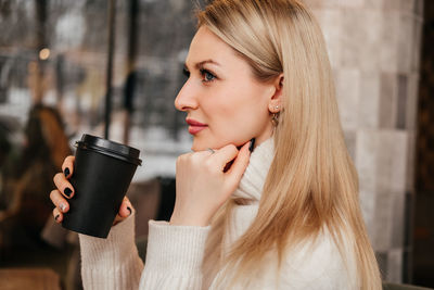 Young woman drinking coffee at home