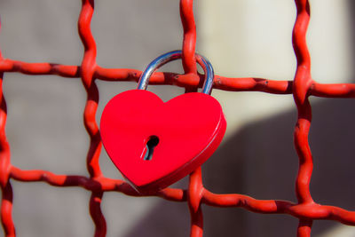 Close-up of love lock hanging on fence