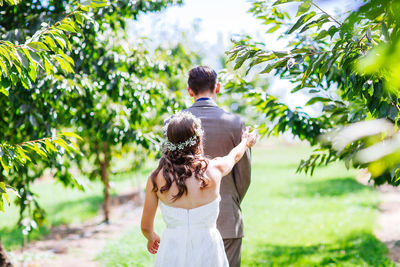 Rear view of couple kissing against trees