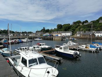 Boats moored at harbor against sky