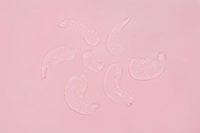 Close-up of water drops against pink background