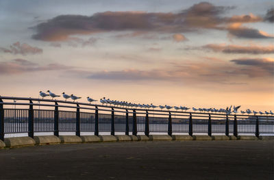 Bridge over sea against sky during sunset