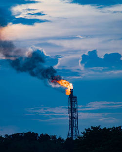 Smoke emitting from chimney against sky