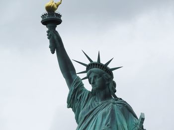 Low angle view of statue of liberty against sky