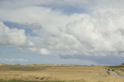 Scenic view of field against cloudy sky