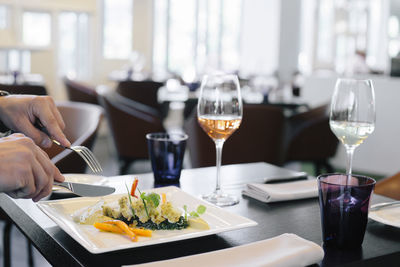 Close-up of woman having food in plate on table