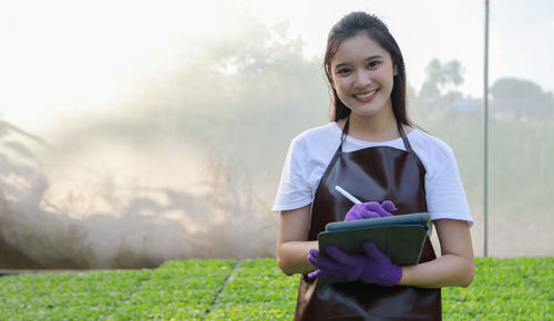 Portrait of smiling girl holding plants