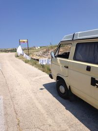 Car on road against clear blue sky