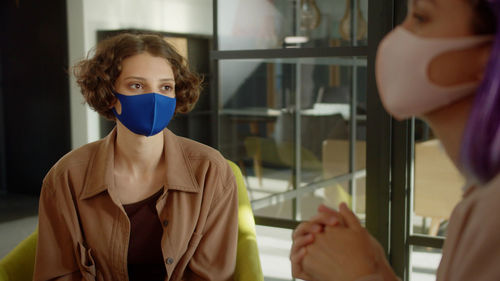 Businesswomen wearing mask sitting at office