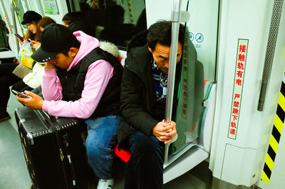 Rear view of man and woman using mobile phone