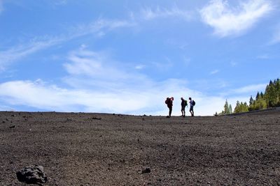 Rear view of people on landscape against sky