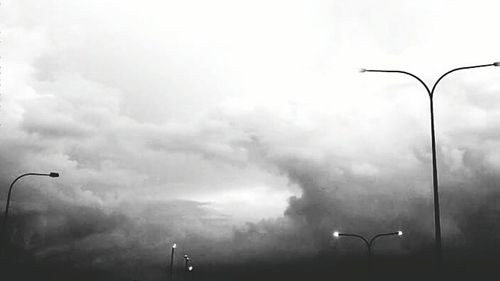 Low angle view of street light against cloudy sky