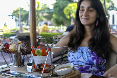 Portrait of young woman sitting on table